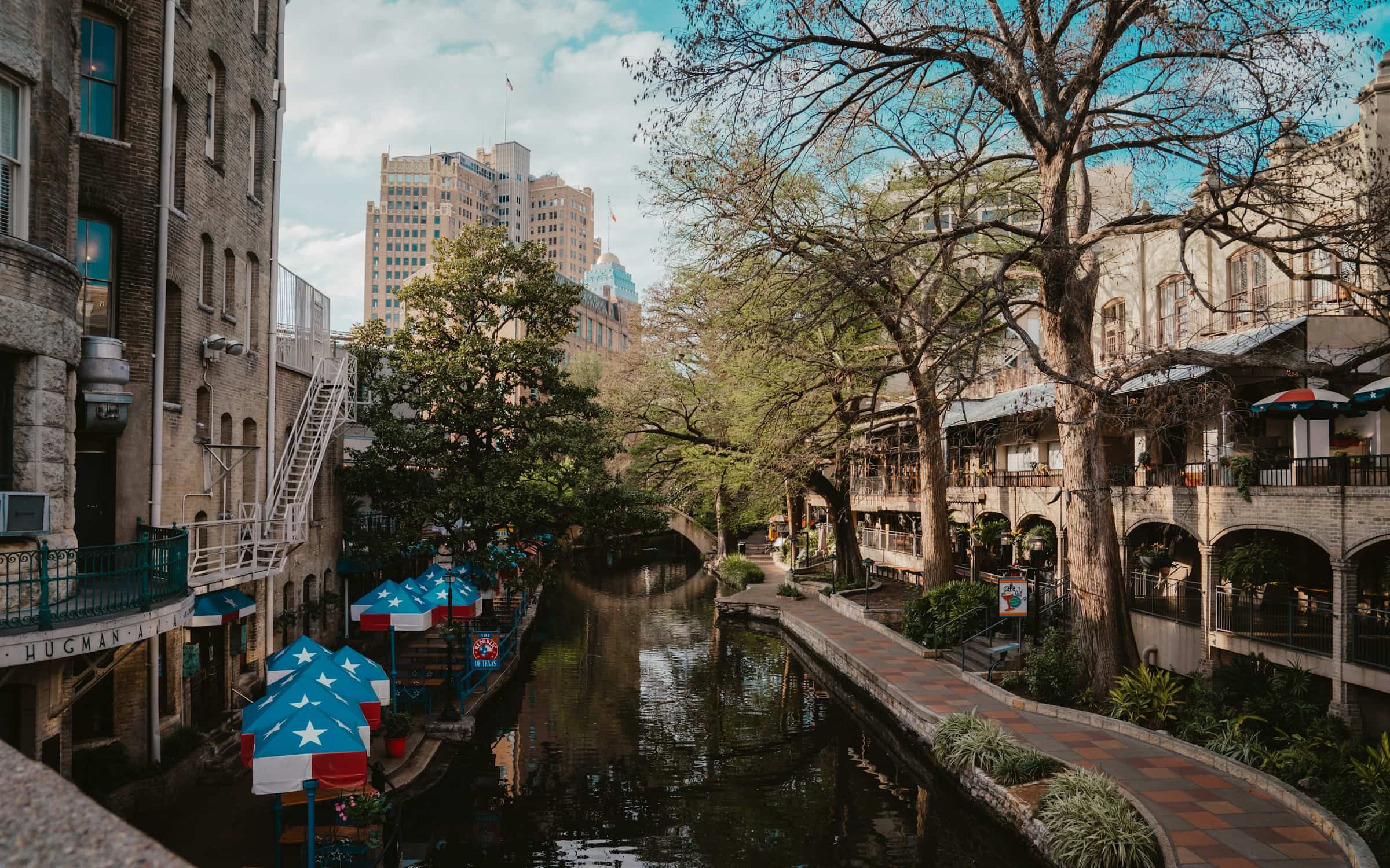 The San Antonio River Walk winding between downtown buildings and cypress trees